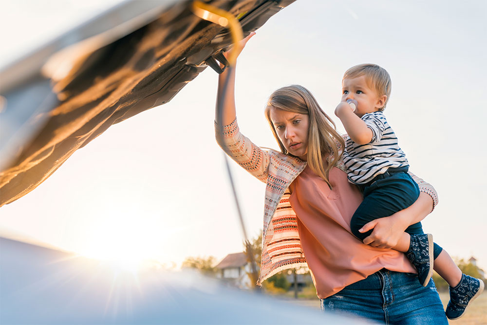 Woman standing by broken down car and got helped by BCAA Road assistance