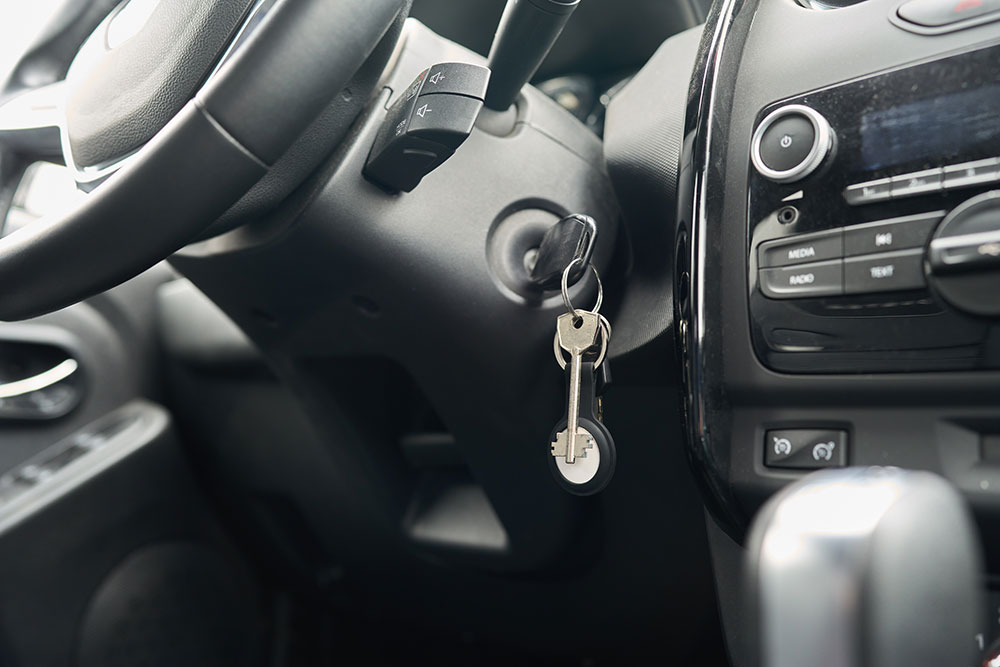 Car keys paired with an AirTag GPS tracker on the keychain