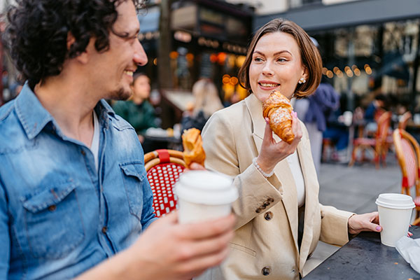 Young Couple Enjoying Coffee and Croissants