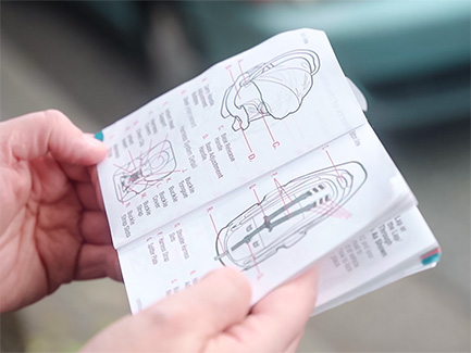 Person holding car seat instruction booklet
