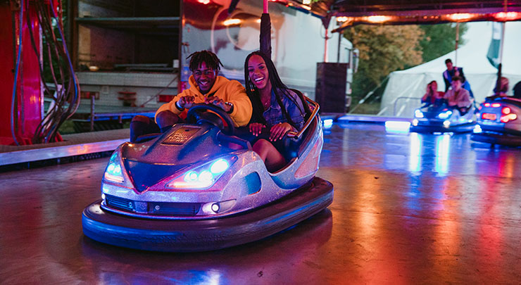 Pair of young people riding in bumper car