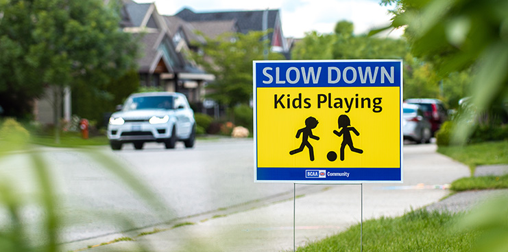 BCAA Slow down kids playing sign with car in the background