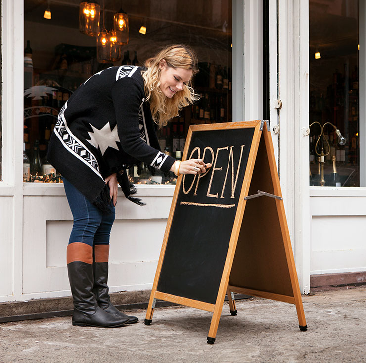 Small Retailer Setting Up Chalk Board