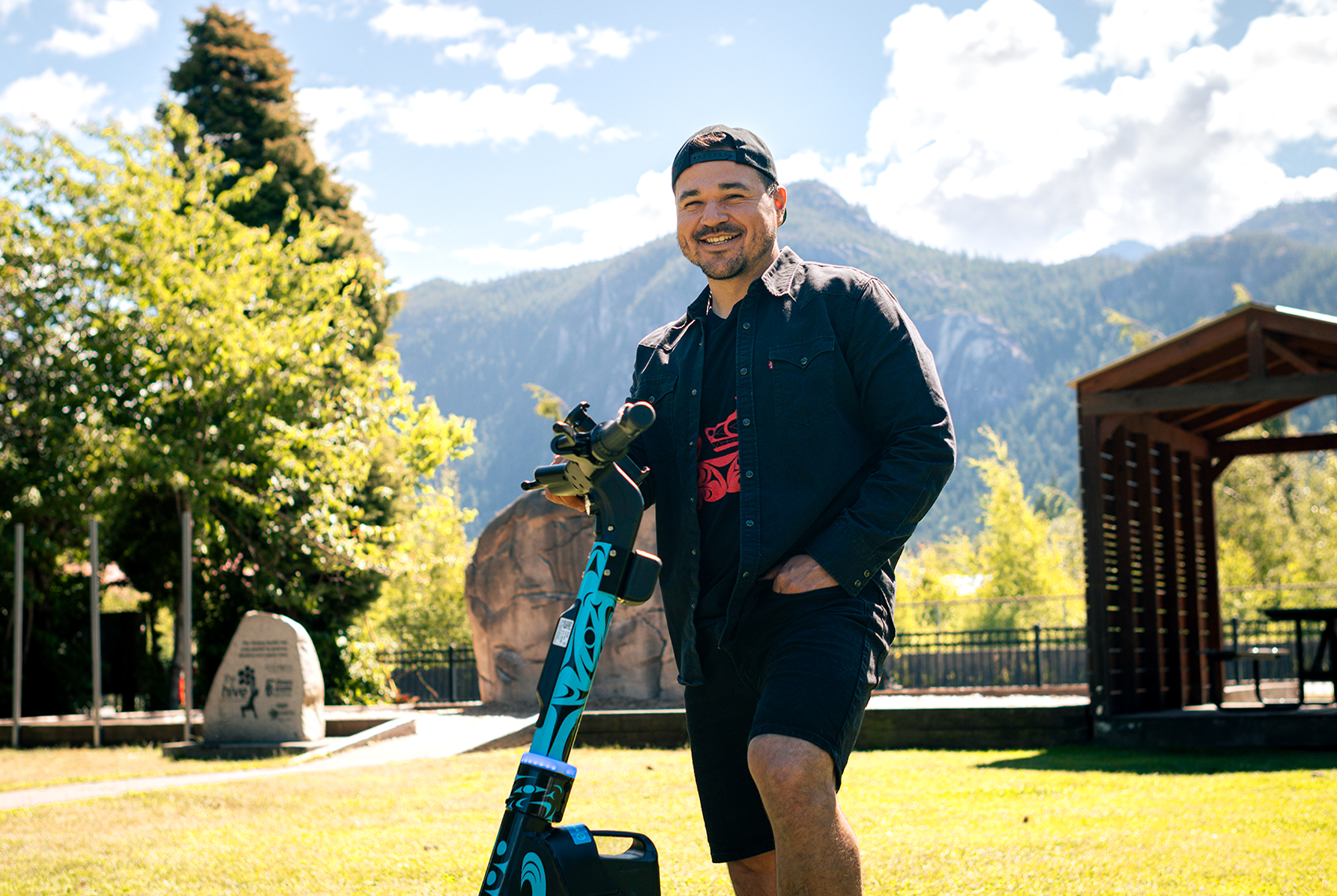 Joshua Watts with Evolve E-Scooter - Artist Smiling