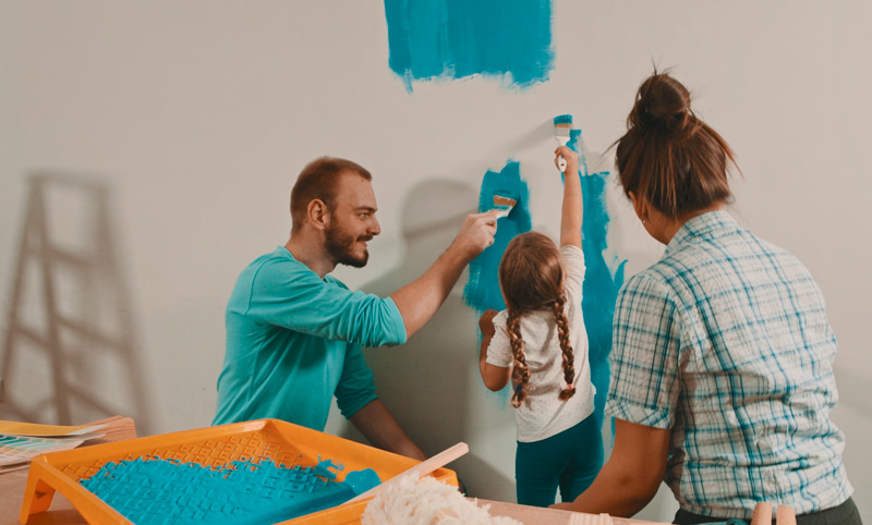 family painting a wall together