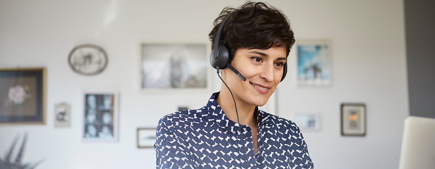 woman wearing headset looking at computer