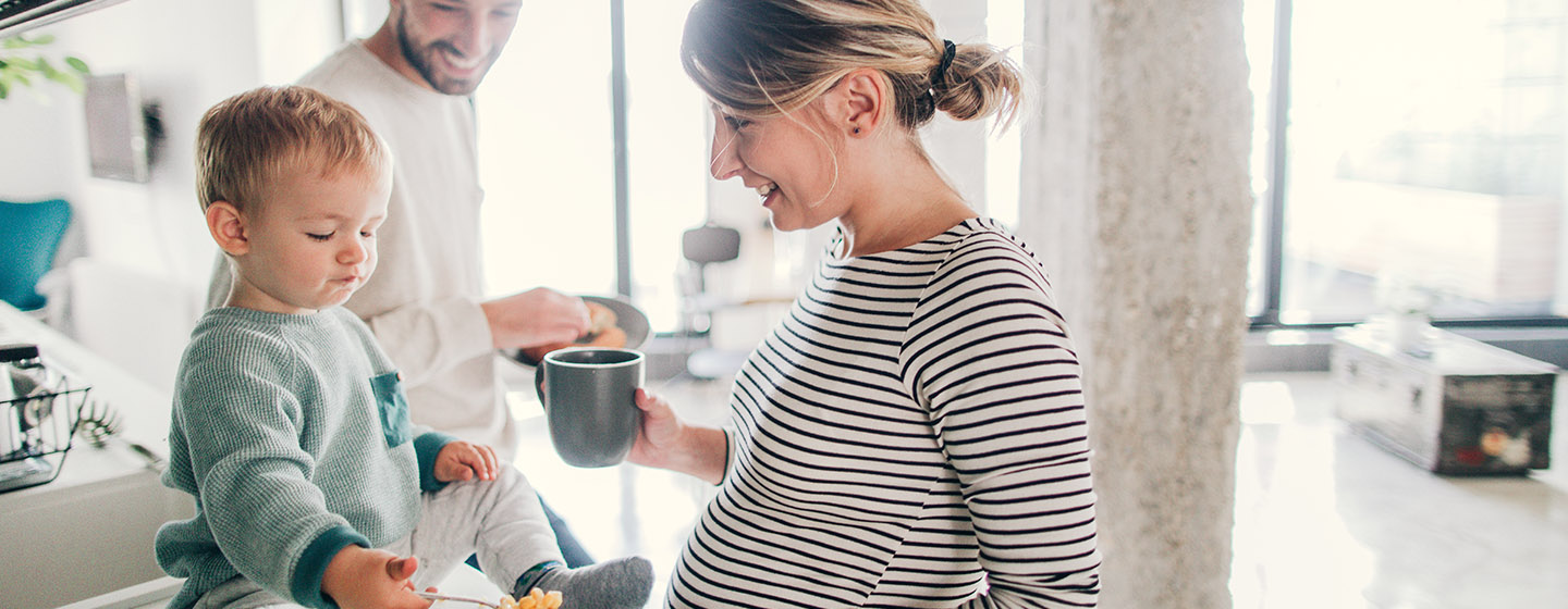 pregnant mother with baby and father in the kitchen