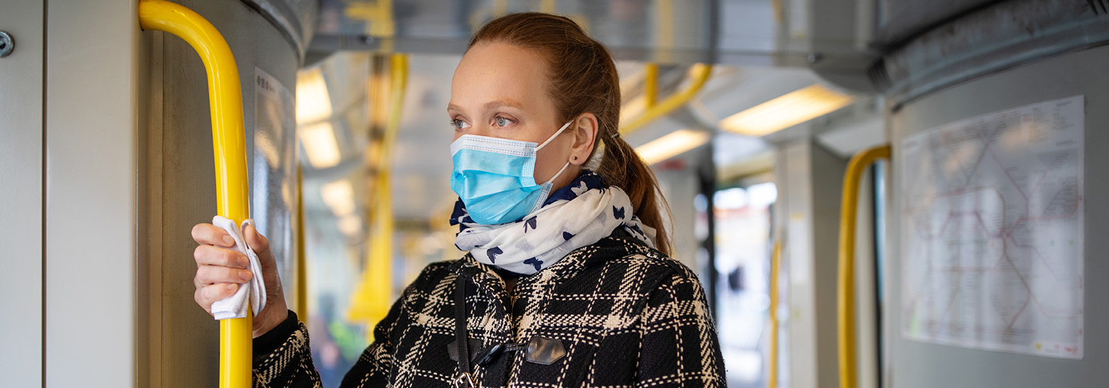 woman with face mask standing on the bus