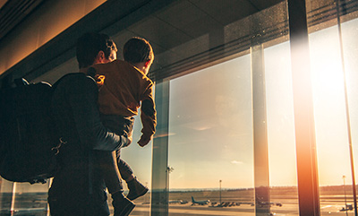 Man and child looking out airport window