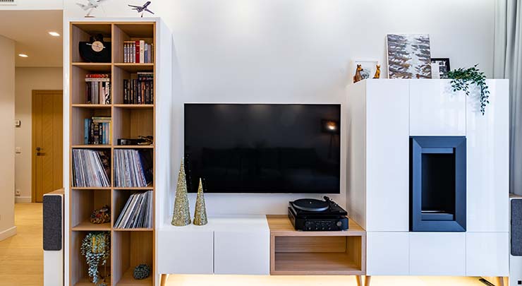 View to living room entertainment center area. Wide screen TV, stereo, turntable, bookshelf, fire place.