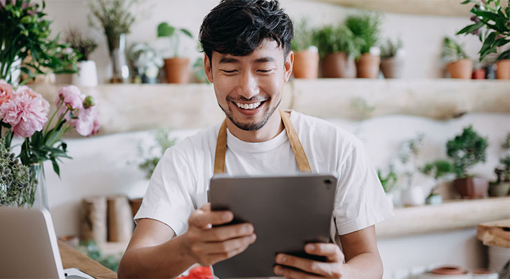 Man is managing his flower shop with his ipad