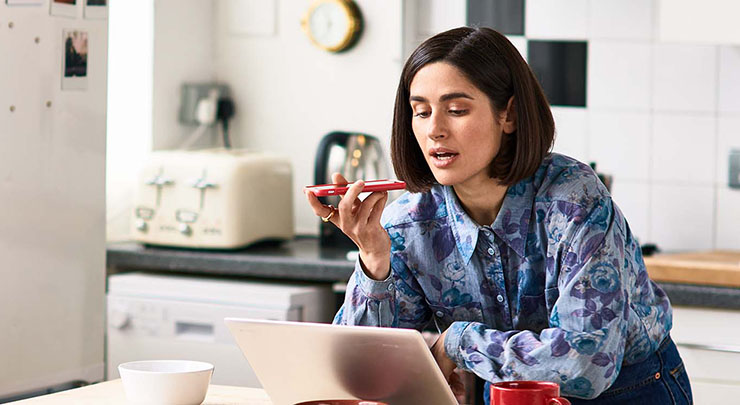 Woman talks on phone in kitchen