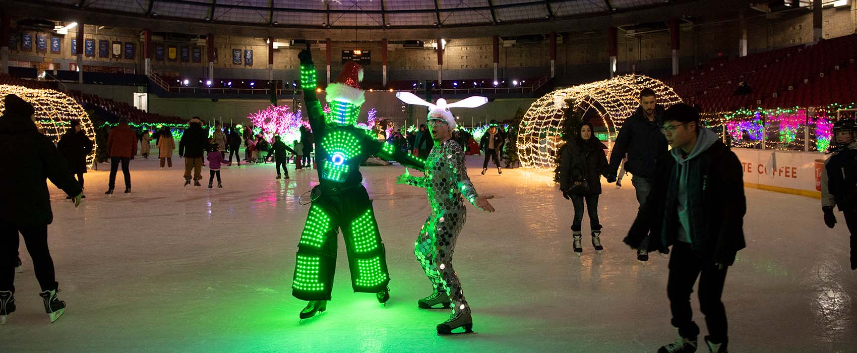 Two people in light-up costumes ice skating