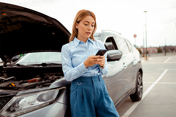 Woman calling a BCAA Road Assist as her car broke down
