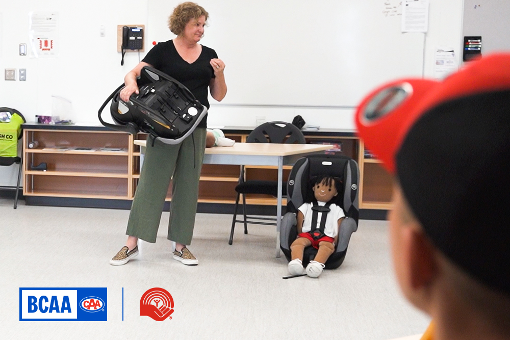 Car seat instructor demonstrating proper car seat belt